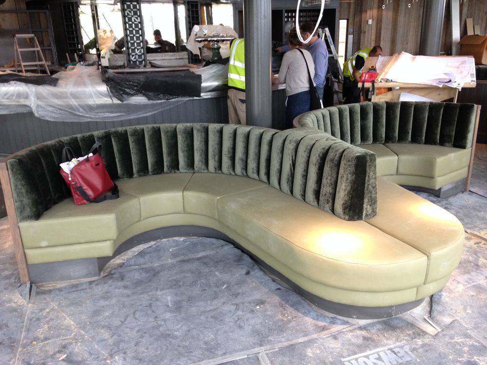 Curved green velvet booth seating